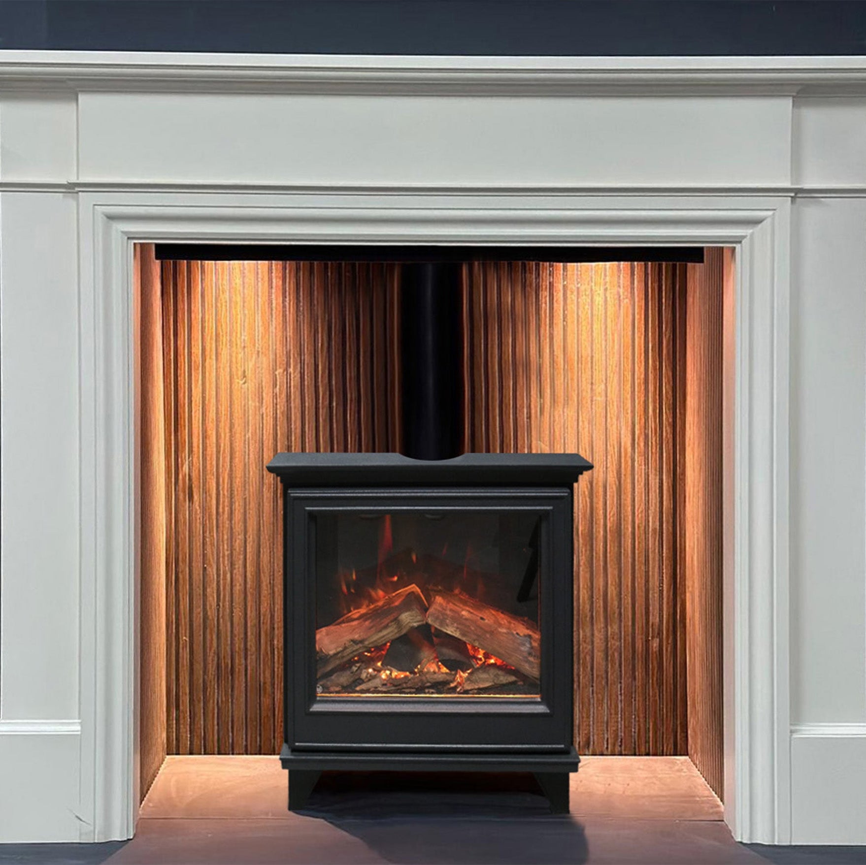 White fireplace mantel with a black electric stove insert and wooden paneling.